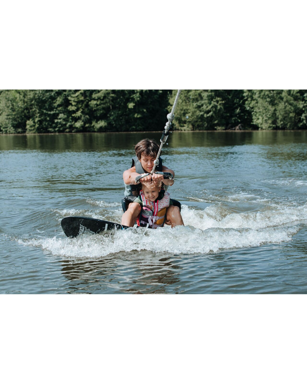 Instructeur die iemand begeleidt op het wakesurfboard tijdens een watersportsessie